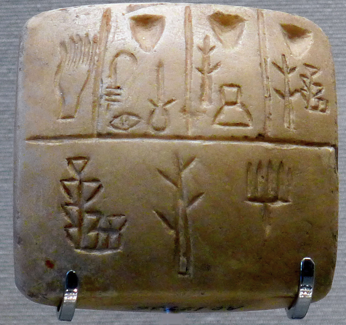 Tablet with proto-cuneiform pictographic characters (end of 4th millennium BC), Uruk III. This is thought to be a list of slaves names, the hand in the upper left corner representing the owner.[25]