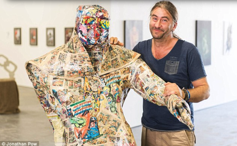 "Oops: Andrew Vickers pictured with his sculpture called Paperboy which he created using £20,000 of comics."