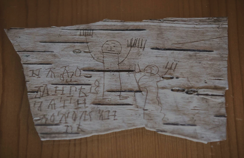 Message and drawing left by a boy on a birch scroll in Old Novgorod language, a precursor to Russian. The scroll was dug from the preservative mud of Veliky Novgorod. (Sergey Ponomarev for The New York Times).