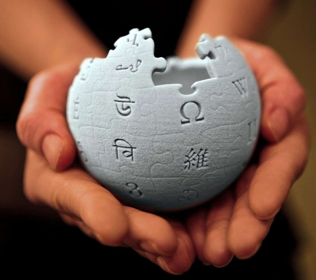 3D model of Wikipedia log held in the palm of two hands