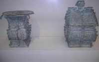 Left item: A Chinese bronze "fang zun" ritual wine container, from the Western Zhou Dynasty, dated c. 1000 BC, excavated in modern-day Luoyang. The written inscription cast in bronze on the v
