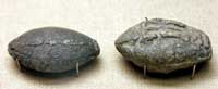 Sling-bolts, or bullets, engraved with a winged lightning-bolt on one side, and the words 'take that' on another. Circa fourth century BCE Athens. (View Larger)