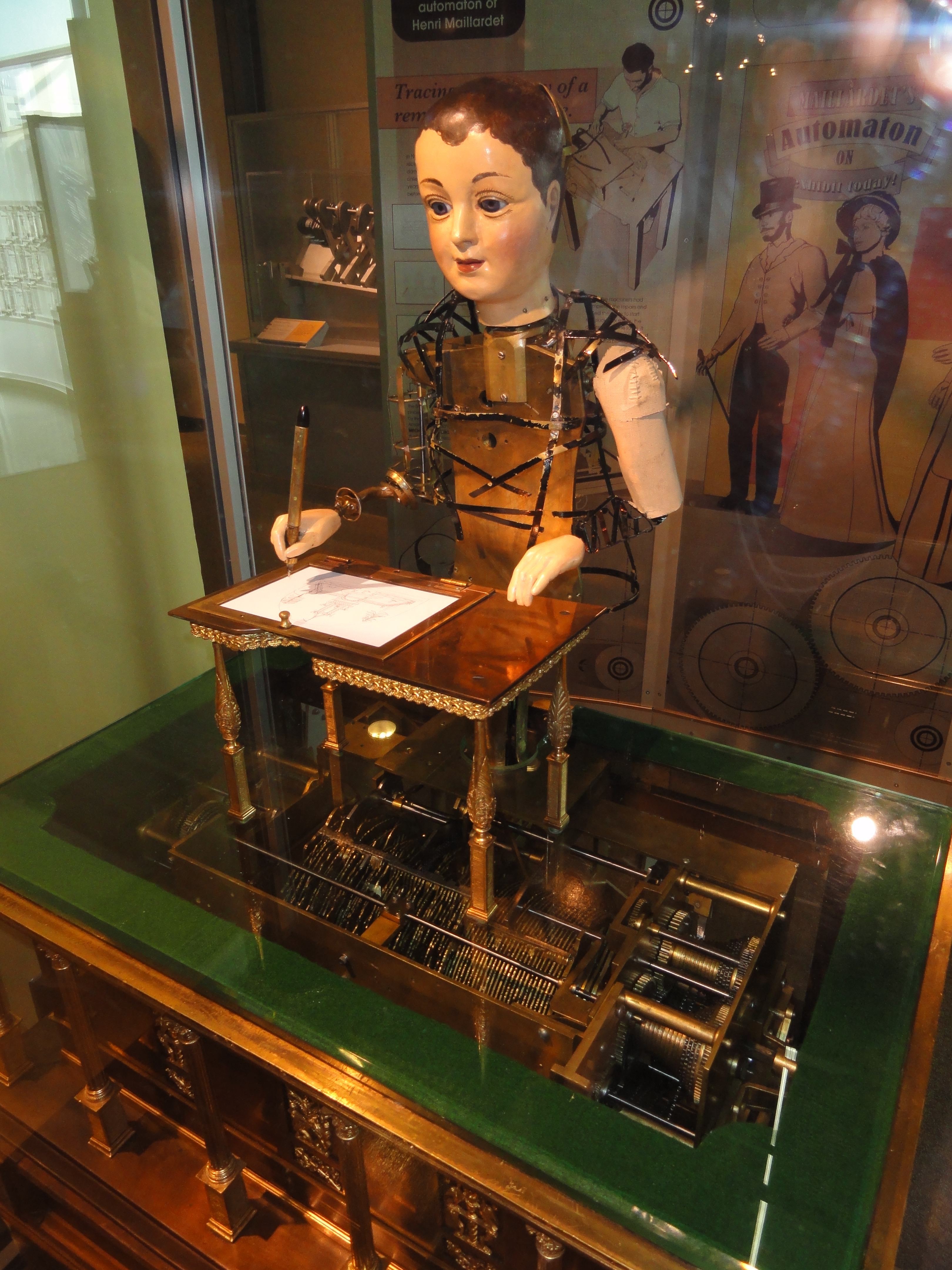 Maillardet's Jeune Enfant without the costume it wears in the video. The very elaborate cam memory is stored in the cabinet beneath the desk.