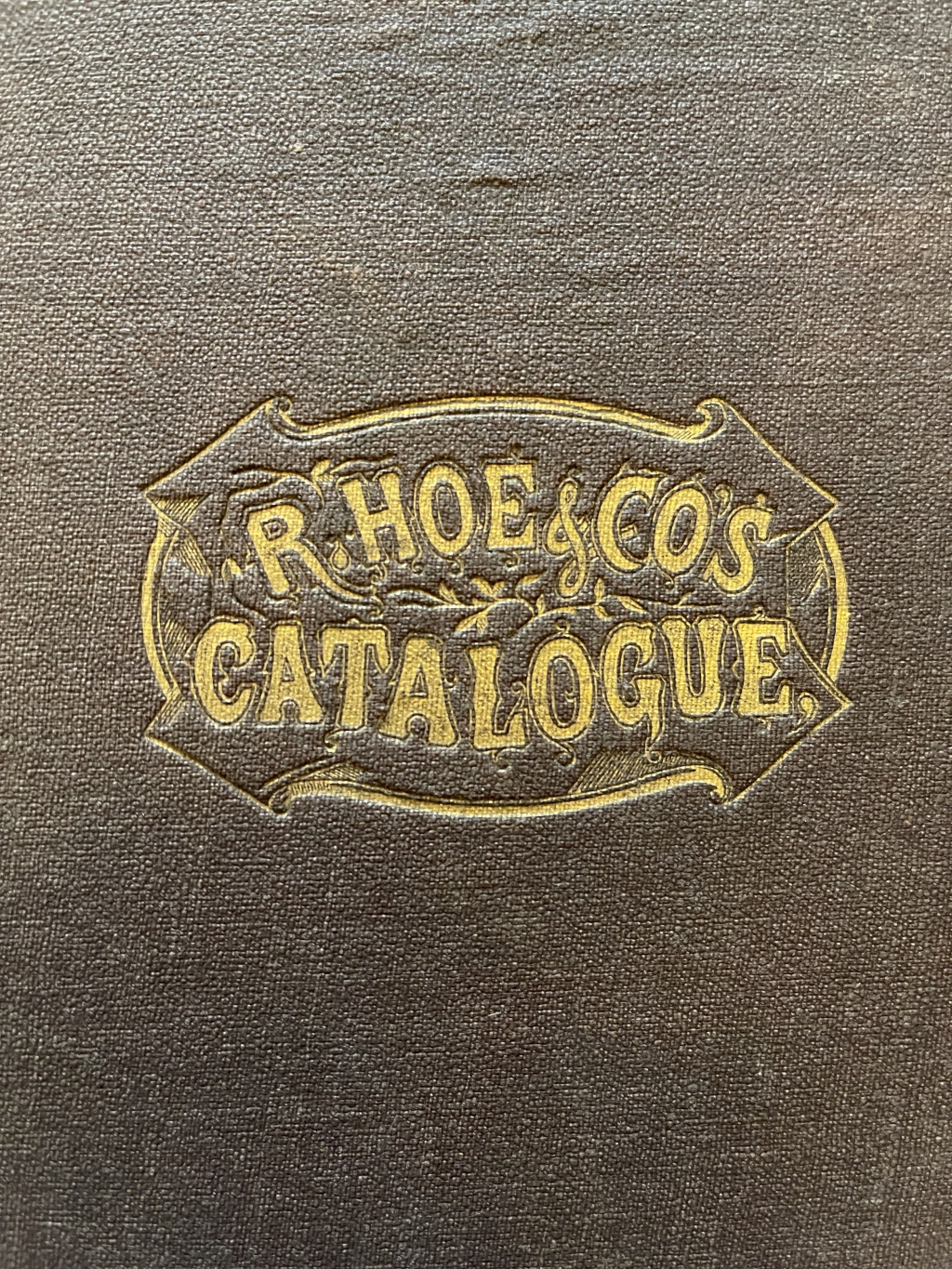 The logo stamped in the center of the upper cover of Hoe's 1873 large quarto format catalogue.
