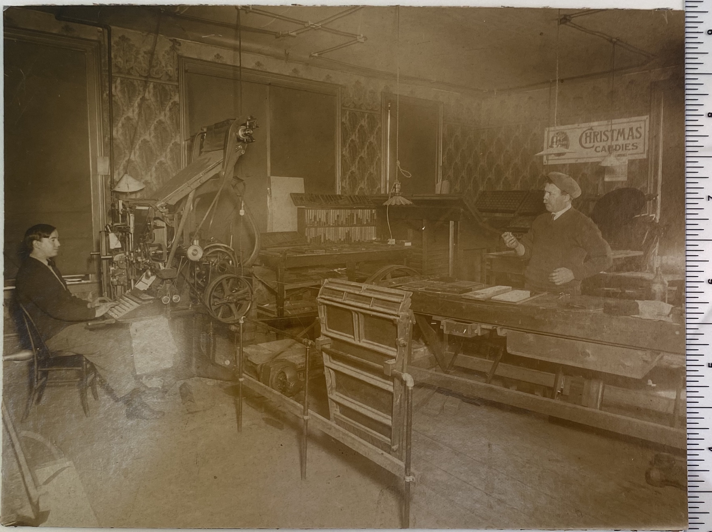 Single Linotype machine and operator in a small printing shop circa 1910