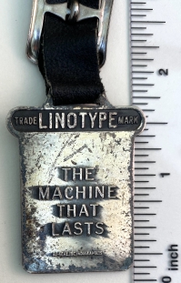Back of the Linotype watch fob with the motto, "The machine that lasts."