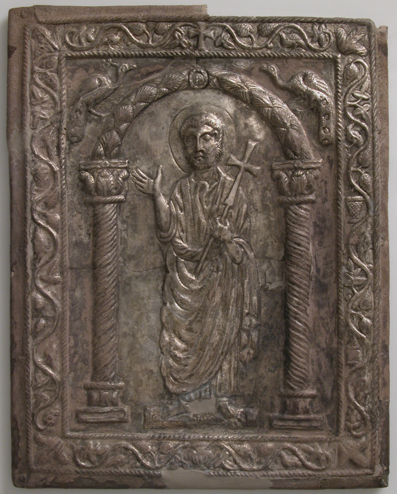 Byzantine repousse silver bookbinding cover depicting St. Peter, holding a cross and gesturing as if preaching. At his waste are the keys to the kingdom of heaven given to him by Christ (Matthew 16;19). "The arch flanked by peacocks under which Peter stands is considered a representation of paradise in early Christian art.