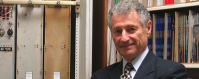 Leonard Kleinrock in his office with parts of the Internet packet switch exposed.