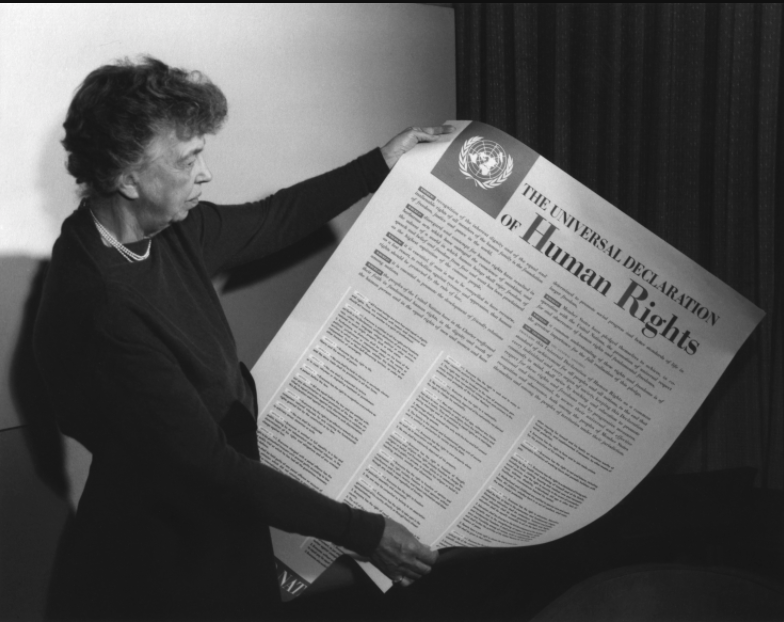 Eleanor Roosevelt holding a poster of the English language version of the Universal Declaration of Human Rights, Lake Success, New York, November, 1949.
