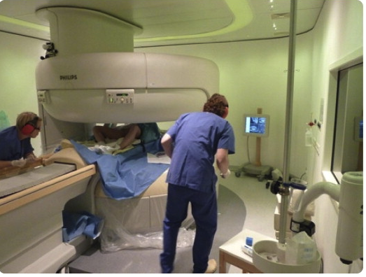 FIGURE 1Photograph of the open MRI scanner with the patient and the health care personnel before delivery