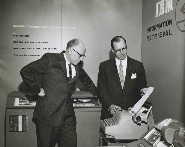 Hans Peter Luhn [right] demonstrates an IBM system for automatically generating indexes of documents, based on KWIC, Key Word in Context.
