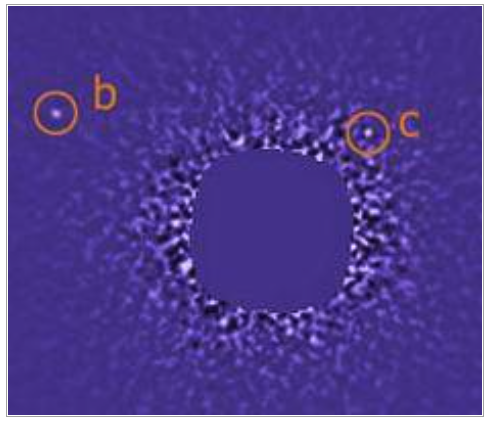 Image from the Gemini Telescope shows two of the three planets in the extrasolar "first family," labeled b and c. The central star has been blotted out to remove its glare.