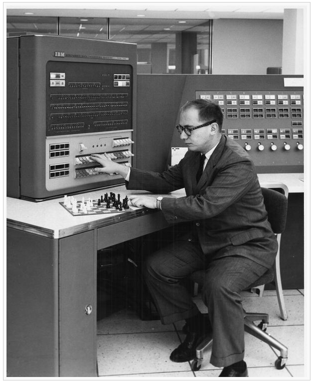 IBM programmer Alex Bernstein playing his chess program at the console of the 704 mainframe. Bernstein told the computer what move to make by flipping the switches on the front panel. The pro