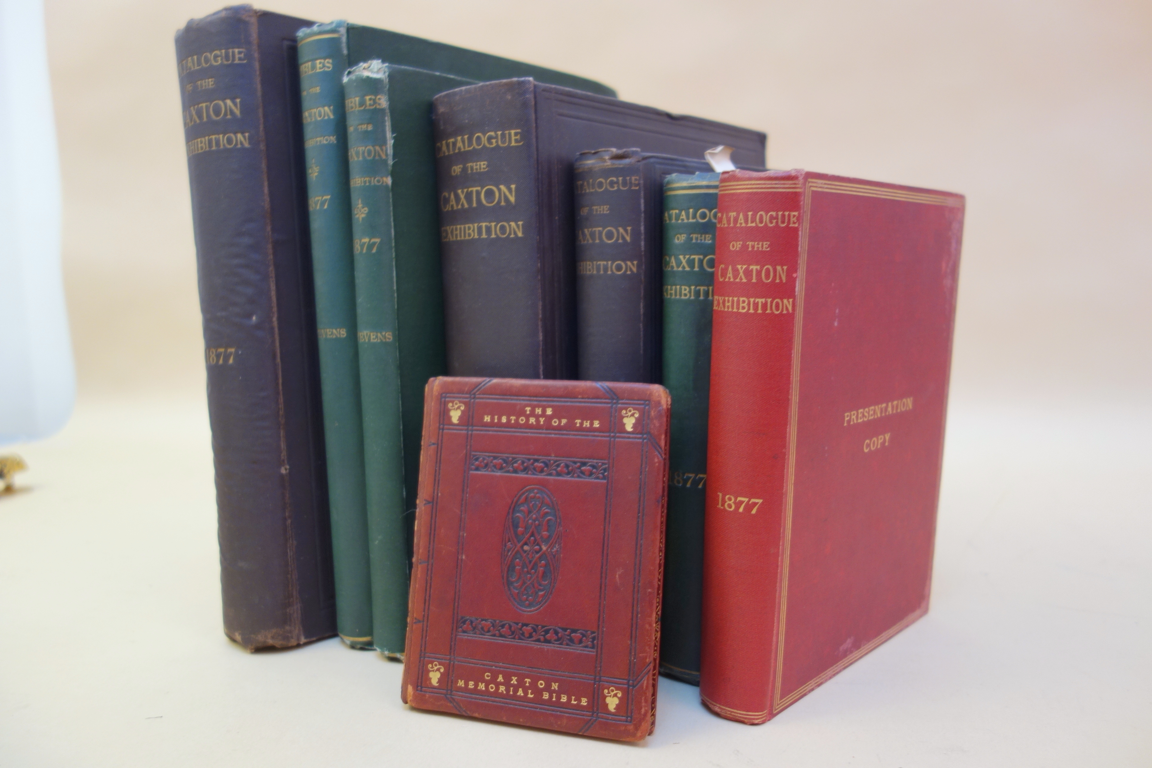 These are the variants of the cloth-bound catalogues of the Caxton Exhibition arranged in descending order by size; there were also versions issued in printed wrappers. The larger, thicker volumes in dark brown cloth are an extra large paper copy and a regular large paper copy; both versions of the large paper copies were issued on hand-made paper.